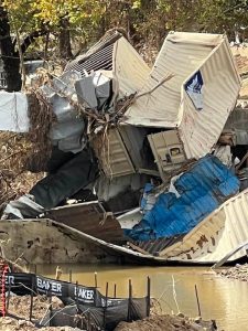 Photo showing Hurricane Helene's damage in North Carolina, piles of metal shipping containers, crushed, bent and broken in a pile.